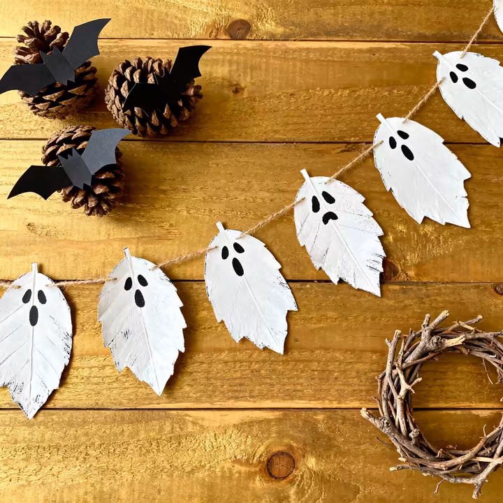 A collection of DIY Halloween decorations made from natural, foraged materials like leaves, pinecones, and branches.